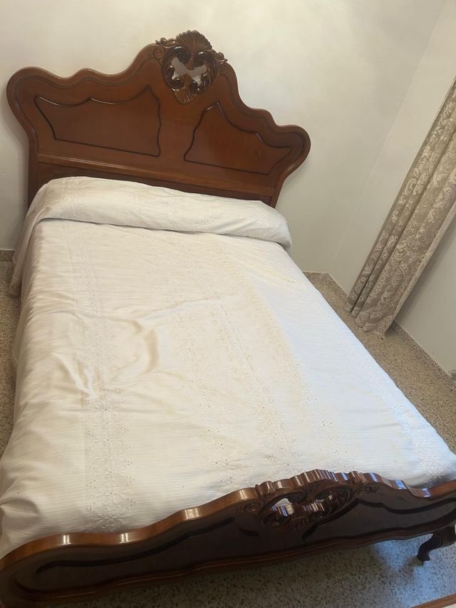 Letto in legno con testiera intagliata