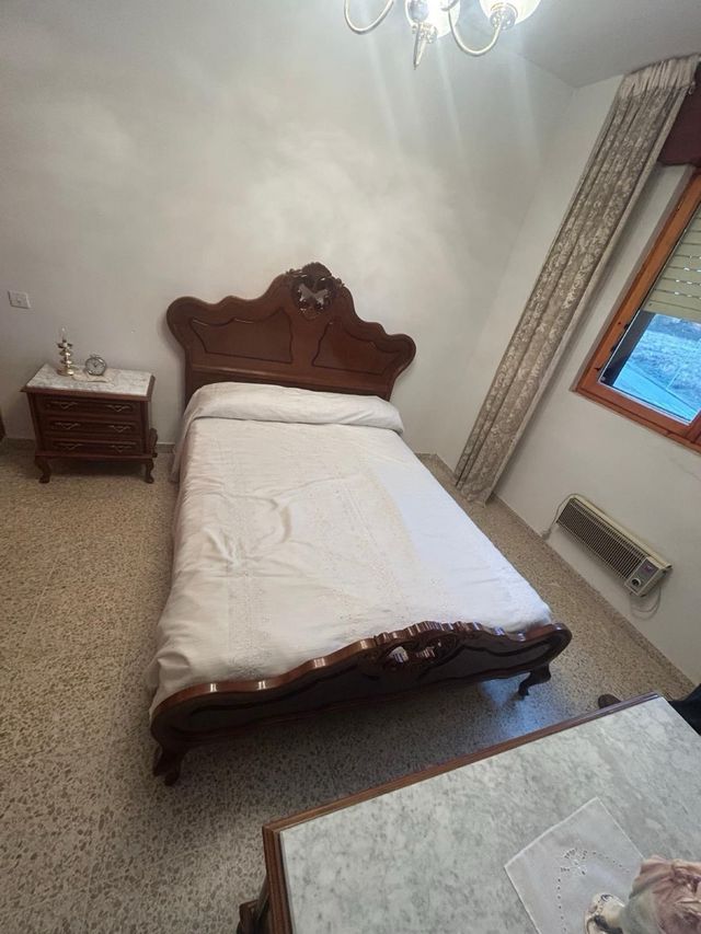 Letto in legno con testiera intagliata