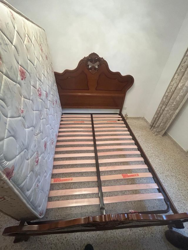 Letto in legno con testiera intagliata