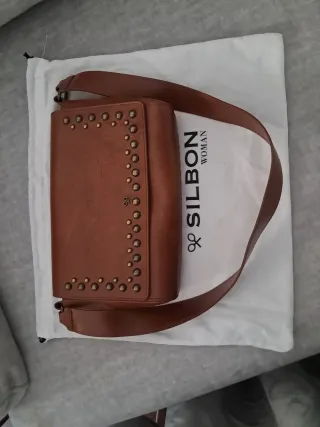 Bolso de piel marrón con tachuelas