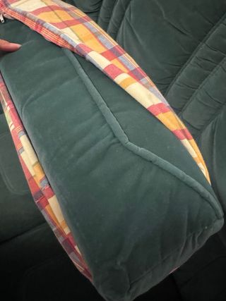 Sofá de tela verde con detalles de madera