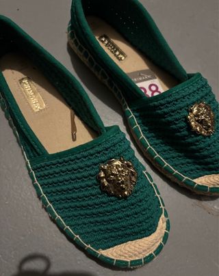 Alpargatas verdes con tachuela de un león dorado