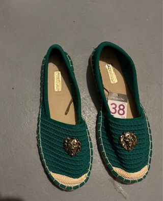 Alpargatas verdes con tachuela de un león dorado