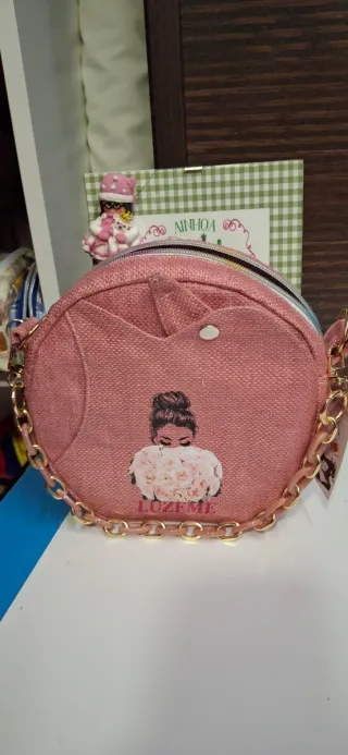 Bolso redondo artesanal rosa con cadena dorada