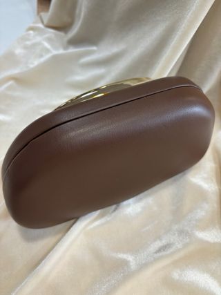 Bolso de mano marrón con asa dorada