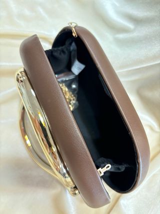Bolso de mano marrón con asa dorada
