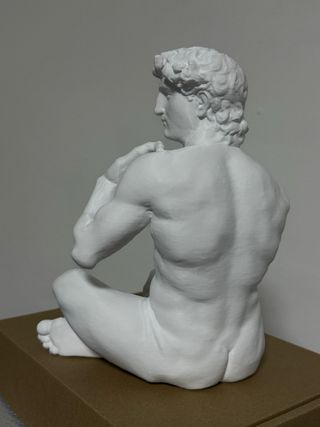 Statua David seduto in plastica bianca