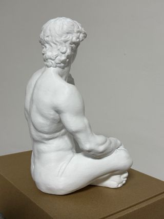 Statua David seduto in plastica bianca