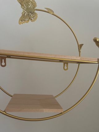 Estantería dorada con mariposa y pájaro