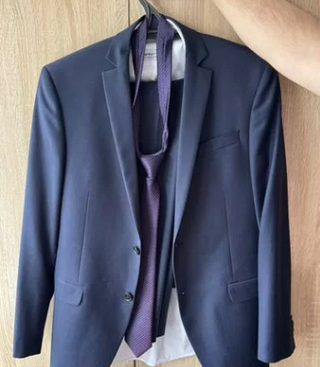 Traje de hombre azul con corbata morada