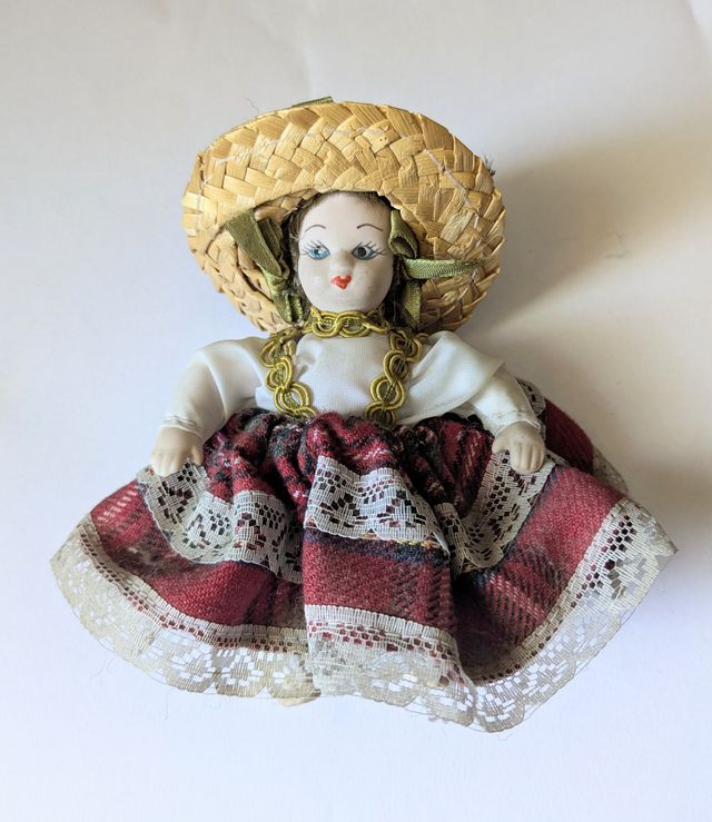 Bambola in porcellana con cappello di paglia