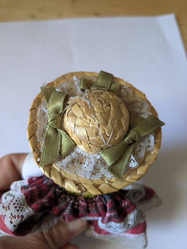 Bambola in porcellana con cappello di paglia