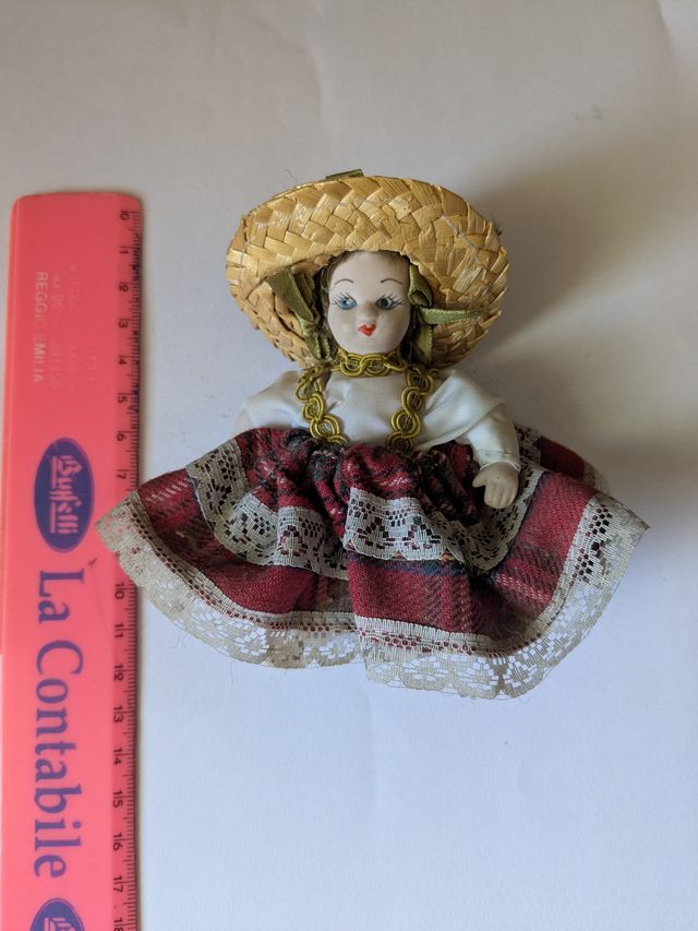 Bambola in porcellana con cappello di paglia