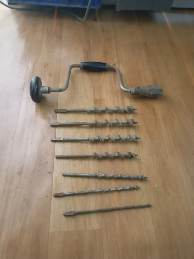 Taladro manual antiguo con brocas