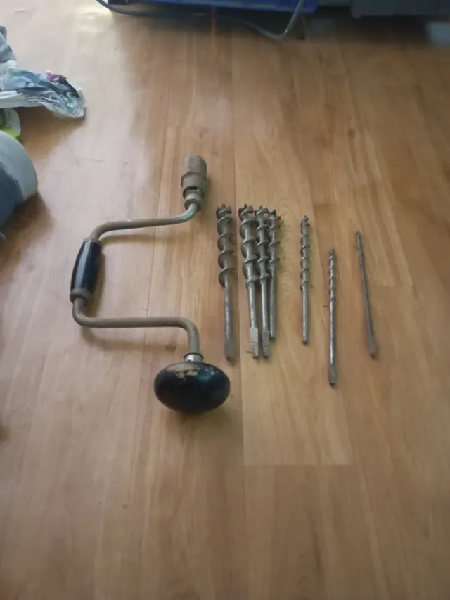 Taladro manual antiguo con brocas