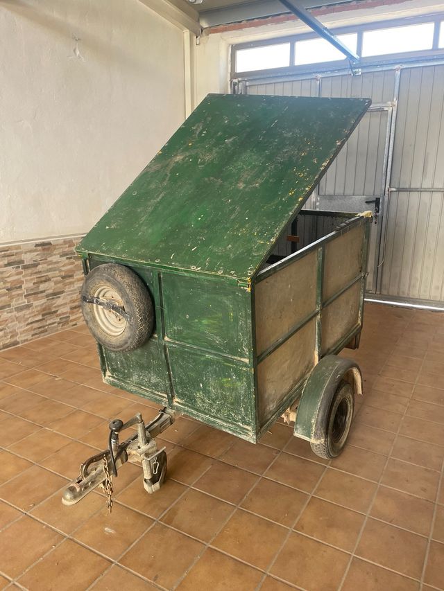 Remolque de carga verde con rueda de repuesto