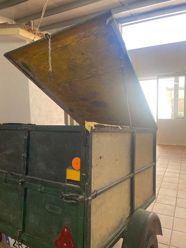 Remolque de carga verde con rueda de repuesto