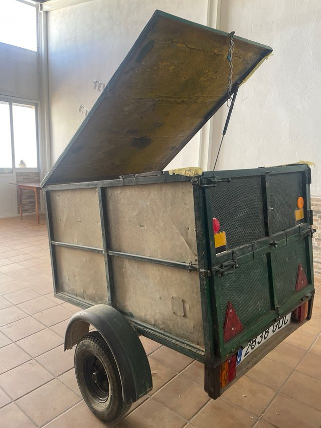 Remolque de carga verde con rueda de repuesto