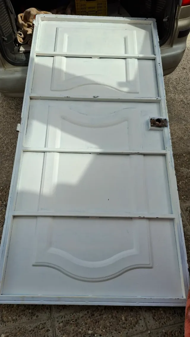 Puerta de entrada blanca,no tiene marco ni llave.