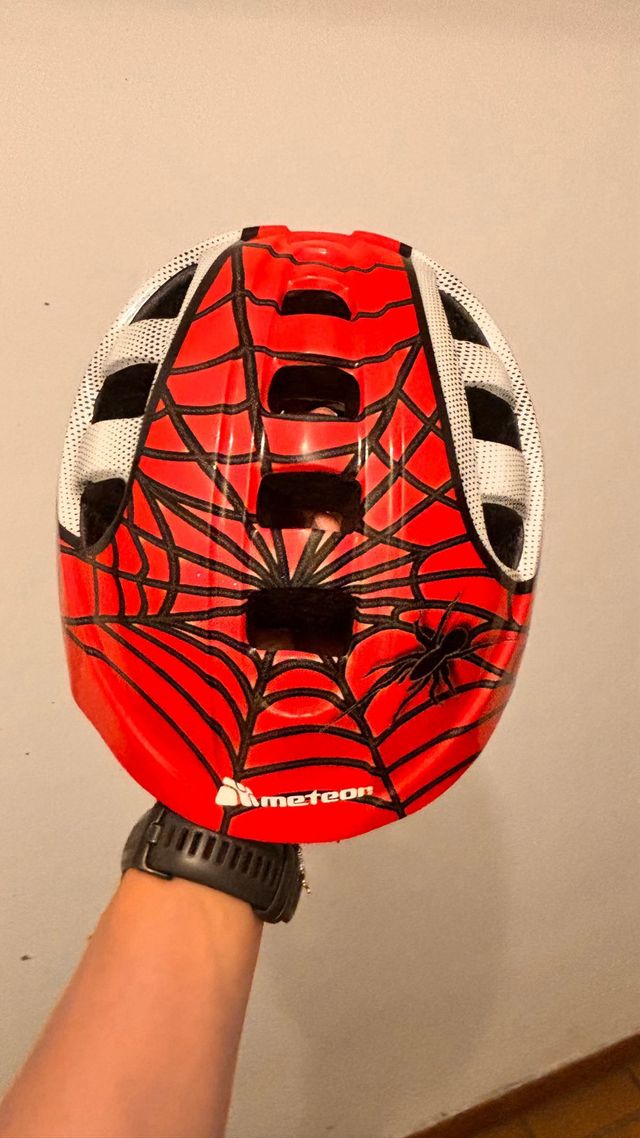 Casco infantil rojo con diseño de araña