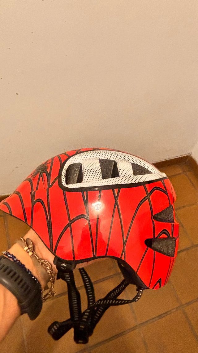 Casco infantil rojo con diseño de araña