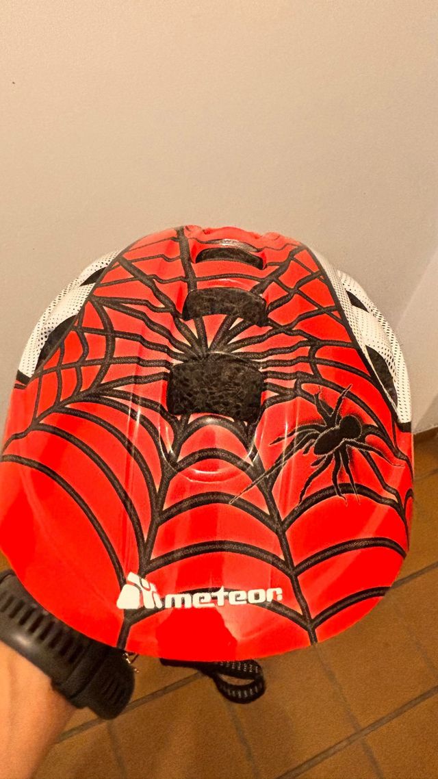 Casco infantil rojo con diseño de araña