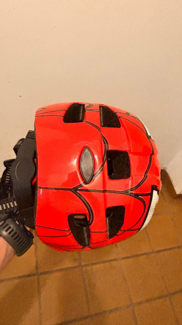 Casco infantil rojo con diseño de araña
