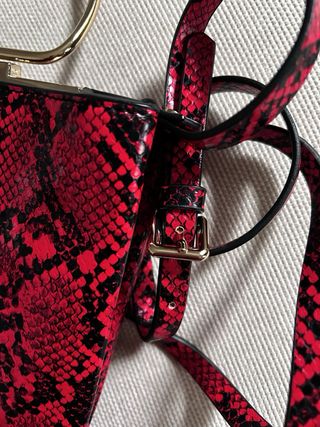 Bolso rojo estampado serpiente con asa dorada
