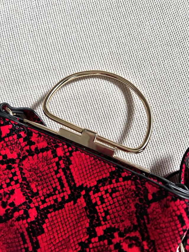 Bolso rojo estampado serpiente con asa dorada