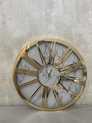 Reloj de pared dorado con números romanos