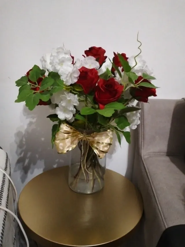 Jarrón de rosas rojas y flores blancas