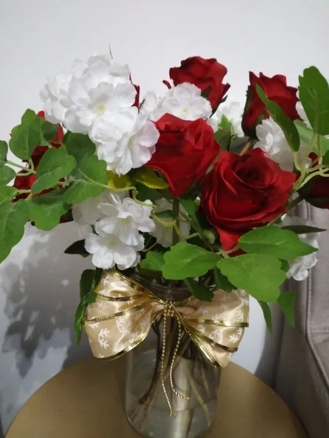 Jarrón de rosas rojas y flores blancas