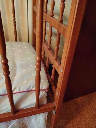 Cuna de madera con colchón y sábanas