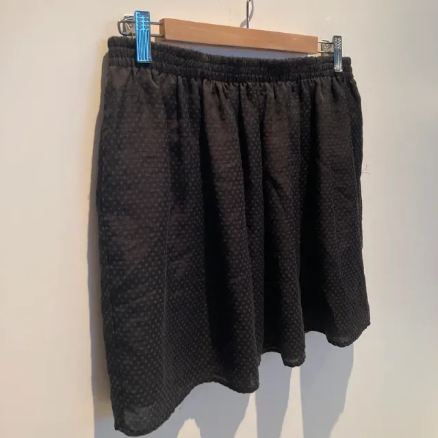 Falda negra ligera con estampado en topos.