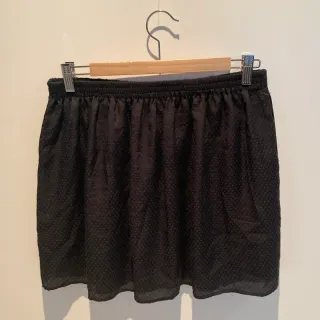 Falda negra ligera con estampado en topos.