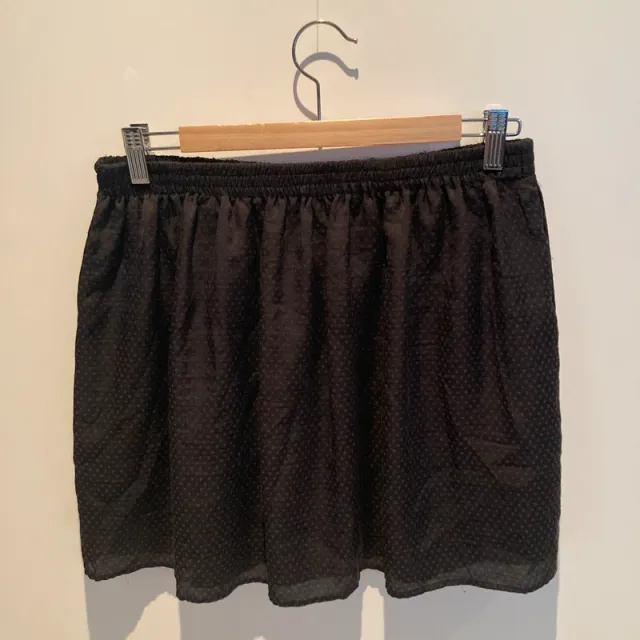 Falda negra ligera con estampado en topos.