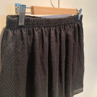 Falda negra ligera con estampado en topos.
