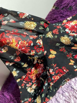 Blusa negra con volantes y estampado floral