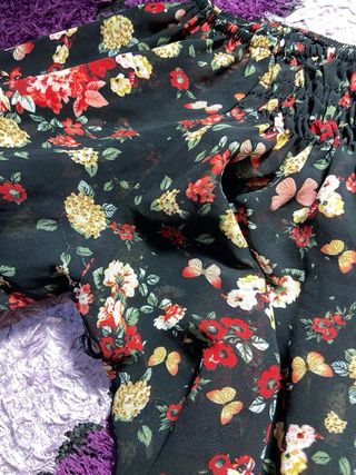 Blusa negra con volantes y estampado floral