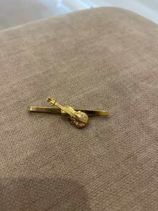Gemelo de corbata dorado con violín
