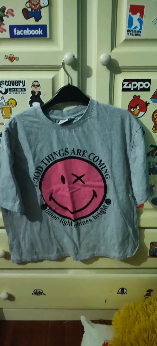 Camiseta gris con smiley rosa