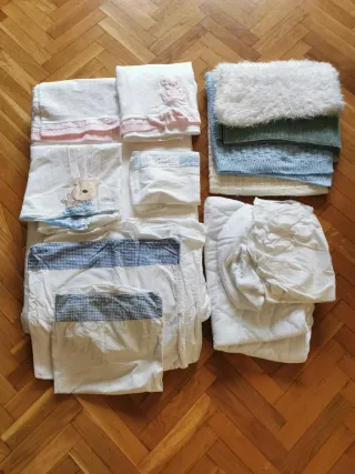 Minicuna azul con sábanas y mantas