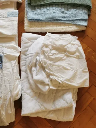 Minicuna azul con sábanas y mantas