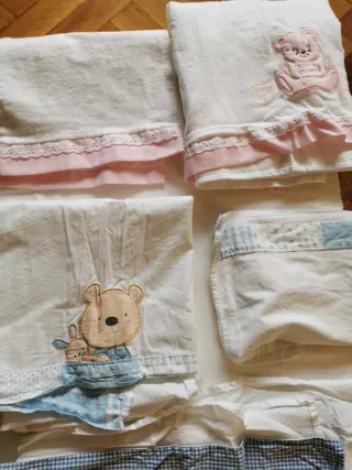 Minicuna azul con sábanas y mantas