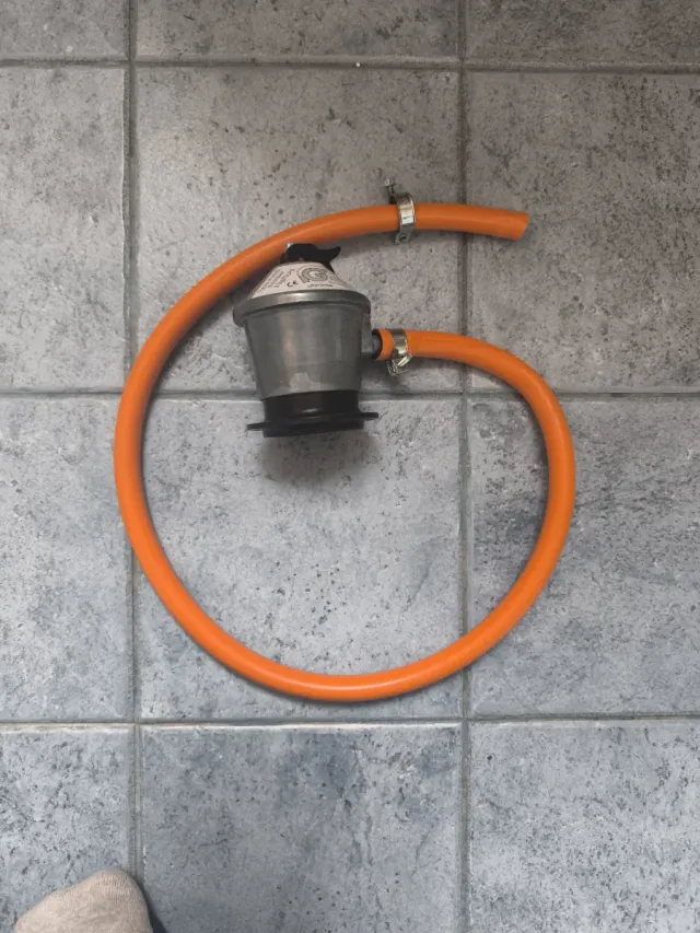 Manguera y regulador bombona gas.