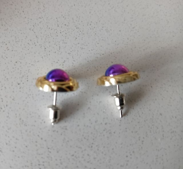Pendientes dorados con detalles morados