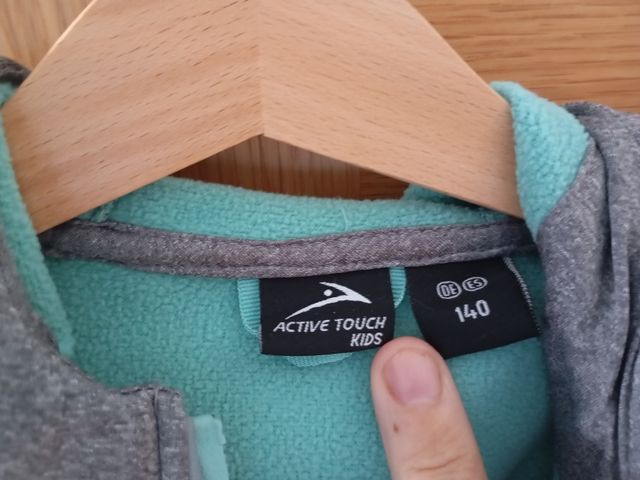 Chaqueta gris con cremallera turquesa