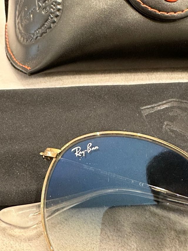 Gafas de Sol Ray-Ban doradas con cristal azul.