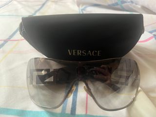 Gafas de sol Versace negras, detalle de joyas.