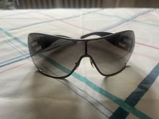 Gafas de sol Versace negras, detalle de joyas.